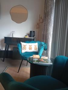 a living room with a blue couch and a table at The Snug on The Brae in Inverness