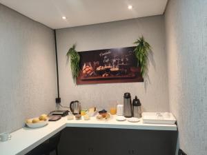 a kitchen with a counter with food on it at Hotel Anoitecer - 100 metros metrô Carandiru, 700 metros Rodoviária do Tietê, 900 metros Aeroporto Campo de Marte, 1,4 km Expor center norte, 1,8 km Distrito do anhembi! Oferecemos como cortesia café da manhã e estacionamento! in São Paulo +32 photos