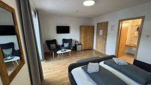 a bedroom with a bed and chairs in a room at Pension Bergfried in Hallstatt +28 photos