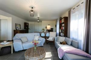 a living room with a blue couch and a table at L'Instant Nouveau chambres d'hôtes in Carennac