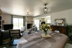 a living room with a table with a vase of flowers on it at L'Instant Nouveau chambres d'hôtes in Carennac