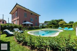 a yard with a swimming pool in front of a building at il buen retiro in Lucca