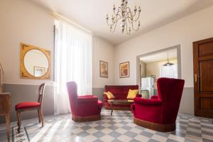 a living room with red chairs and a couch at il buen retiro in Lucca +101 photos