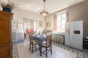 a kitchen with a table with chairs and a refrigerator at il buen retiro in Lucca