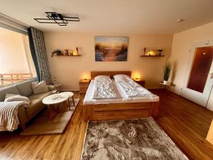 a bedroom with a large bed and a couch at Trafalgar Apartment 133 in Cuxhaven +42 photos