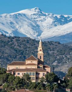 a building with a clock tower in front of a mountain at SUEÑOS DEL MAR in Motril