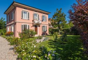 a pink house with a garden in front of it at il buen retiro in Lucca