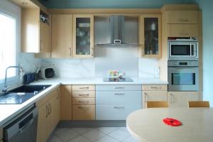 a kitchen with wooden cabinets and a white counter top at Jolie chambre au centre Antony in Antony
