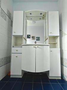 a bathroom with white cabinets and a mirror at Jolie chambre au centre Antony in Antony