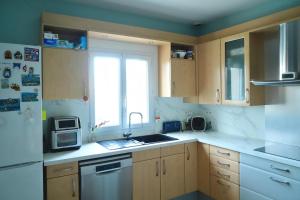 a kitchen with wooden cabinets and a sink and a window at Jolie chambre au centre Antony in Antony +13 photos