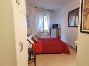 a bedroom with a red bed and a window at appartamento pontevecchio in Florence