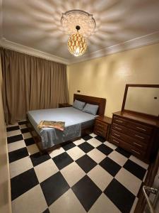 a bedroom with a bed and a checkered floor at Amazing apartment with traditional touch in Taskala