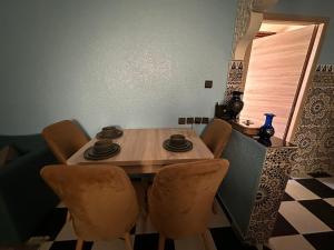 a dining room table with four chairs and a table and a window at Amazing apartment with traditional touch in Taskala +6 photos