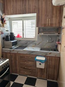 a kitchen with wooden cabinets and a sink at Amazing apartment with traditional touch in Taskala