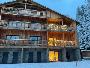 a log cabin with a deck in the snow at Apartmán #7 Mariánská Hora in Albrechtice v Jizerských horách