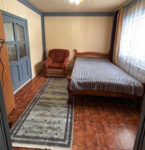 a room with a bed and a chair and a door at Садиба у "Степана" in Synevyrsʼka Polyana +6 photos