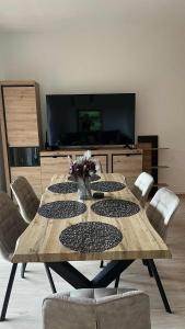 a wooden table with chairs in a room with a television at Apartmán #7 Mariánská Hora in Albrechtice v Jizerských horách
