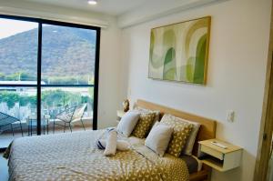 a bedroom with a bed and a large window at Samaia Loft in Santa Marta