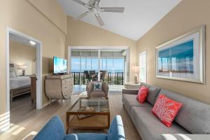 a living room with a couch and a tv and a bedroom at Shell Island Beach Club #5D in Sanibel