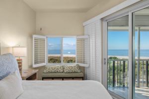a bedroom with a bed and a view of the ocean at Shell Island Beach Club #5D in Sanibel