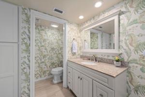 a bathroom with a sink and a toilet and a mirror at Shell Island Beach Club #5D in Sanibel +26 photos