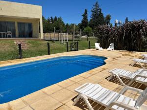 a swimming pool with two lawn chairs and a couple of chairs at El VIEJI in Colón