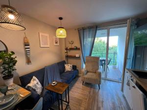a living room with a blue couch and a table at Mewa Studio in Krynica Morska