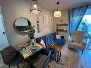 a living room with a blue couch and a table at Mewa Studio in Krynica Morska