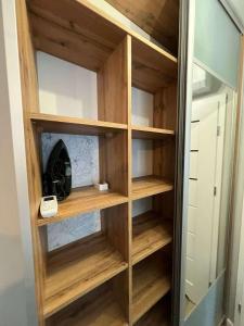 a wooden book shelf in a closet at Mewa Studio in Krynica Morska