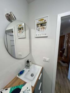 a bathroom with a sink and a mirror at Mewa Studio in Krynica Morska +8 photos