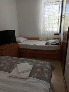 a small bedroom with two beds and a window at Apartment Gajac A7 44 in Novalja