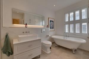 a bathroom with a tub and a sink and a toilet at Modern & homely 2-bed - close to BEACH in Bideford