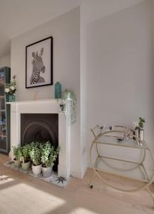 a living room with a fireplace with plants and a tub at Modern & homely 2-bed - close to BEACH in Bideford