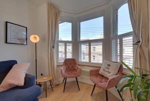 a living room with a couch and chairs and windows at Modern & homely 2-bed - close to BEACH in Bideford