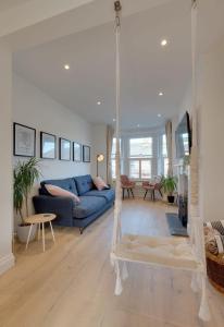 a living room with a blue couch and a swing at Modern & homely 2-bed - close to BEACH in Bideford +21 photos