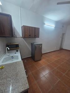 a kitchen with a refrigerator and a tile floor at Furnished Studio - Cite Progres in Djibouti