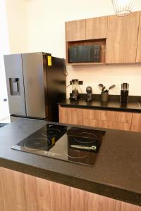 a kitchen with a black counter and a refrigerator at Casa Morrocoy con alberca privada y 3 habitaciones in Cholul