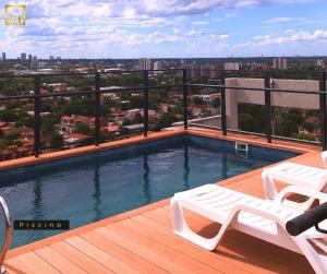 a swimming pool on a balcony with a view of a city at Departamento 1 dormitorio con piscina in Fernando de la Mora