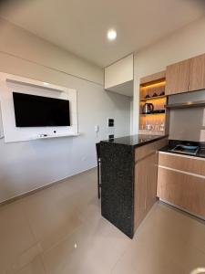 a large kitchen with a flat screen tv on the wall at Departamento 1 dormitorio con piscina in Fernando de la Mora