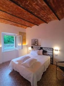 a bedroom with a large white bed with a window at AFFITTACAMERE SobborgoSpina47 in Sarzana