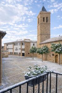 a building with a clock tower and a building with a fence at Apartamento La Plaza in Munera +35 photos