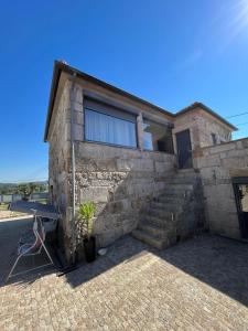 a stone house with a table in front of it at Daisy Country House in Lousada