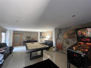 a living room with a pool table and a tv at Daisy Country House in Lousada