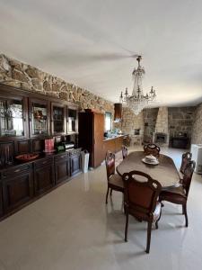 a kitchen with a table and chairs and a chandelier at Daisy Country House in Lousada