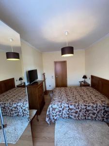 a bedroom with two beds and a tv in it at Daisy Country House in Lousada +21 photos