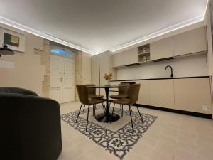 a kitchen with a table and chairs in a room at Romantico bilocale ad Ortigia in Syracuse
