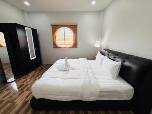a bedroom with a large white bed with a black headboard at AAA villa Aonang Krabi in Ao Nang 