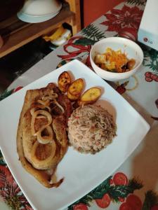 a white plate of food with rice and mushrooms at COTOPAXI Wasi Andina Lodge in Latacunga +20 photos