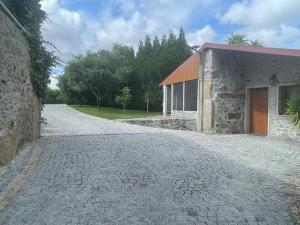 a stone driveway next to a building with a garage at Quinta do Sobrado in Braga
