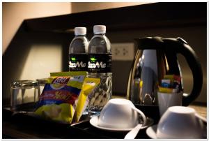 a table with two bottles of water and a tea kettle at Sea Me Spring Hotel in Pattaya